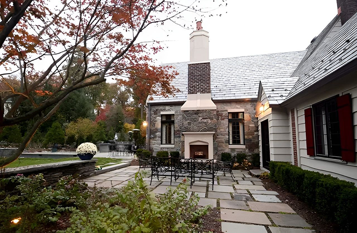 A house with a fireplace and a patio in front of it
