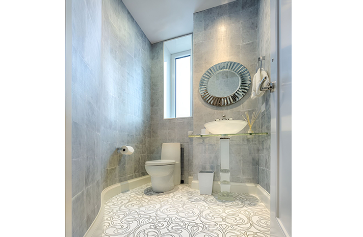 A bathroom with a toilet , sink and mirror.