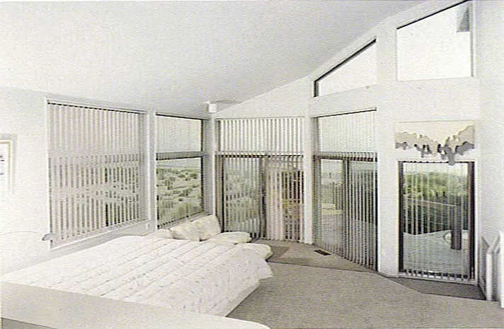 A bedroom with a large bed and lots of windows