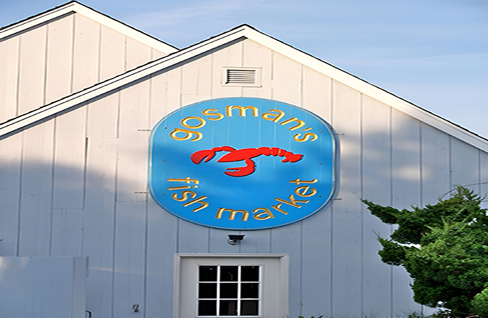 A sign on the side of a building says gosman 's fish market