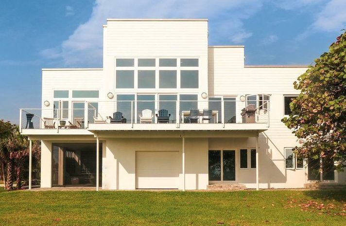 A large white house with a lot of windows and a balcony