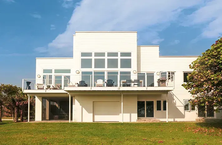 A large white house with a balcony and a lot of windows
