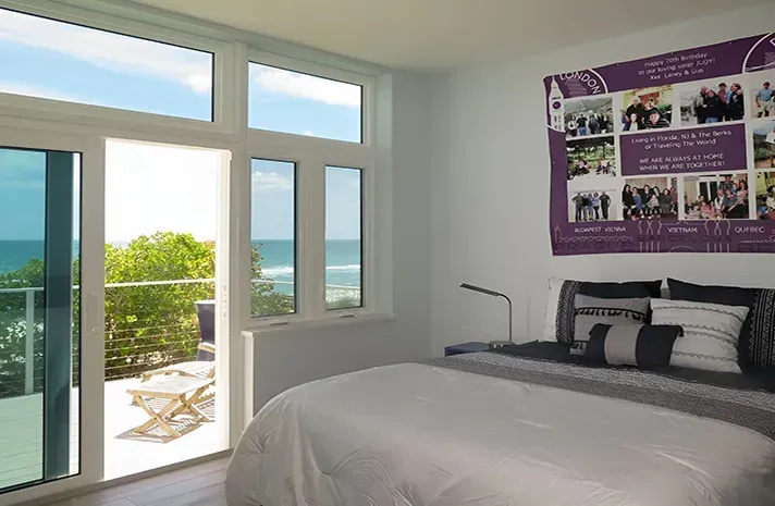 A bedroom with a large bed and a purple poster on the wall.