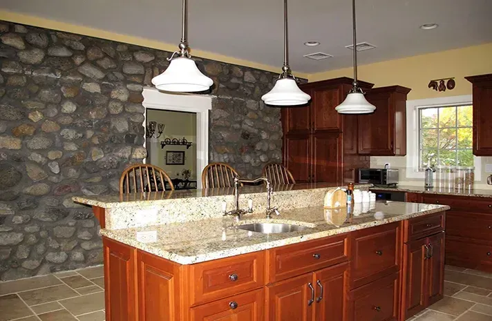 A kitchen with a large island and granite counter tops