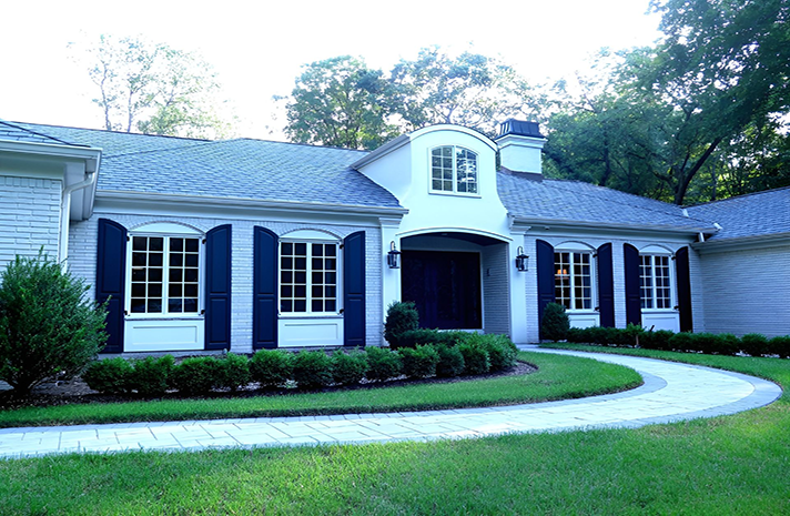 A white house with blue shutters on the windows