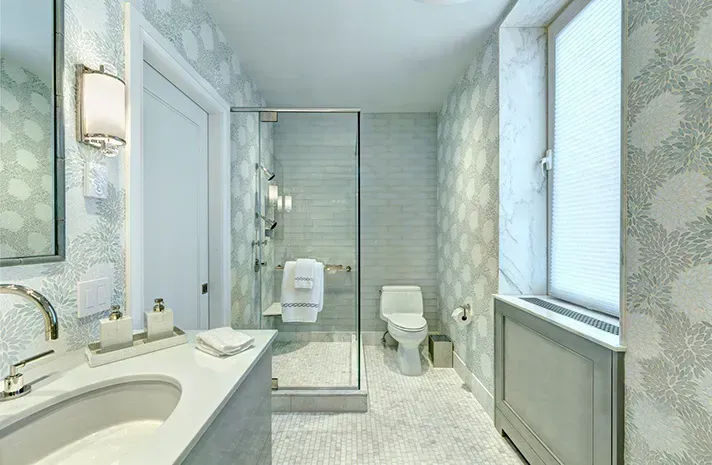 A bathroom with a sink , toilet and walk in shower.