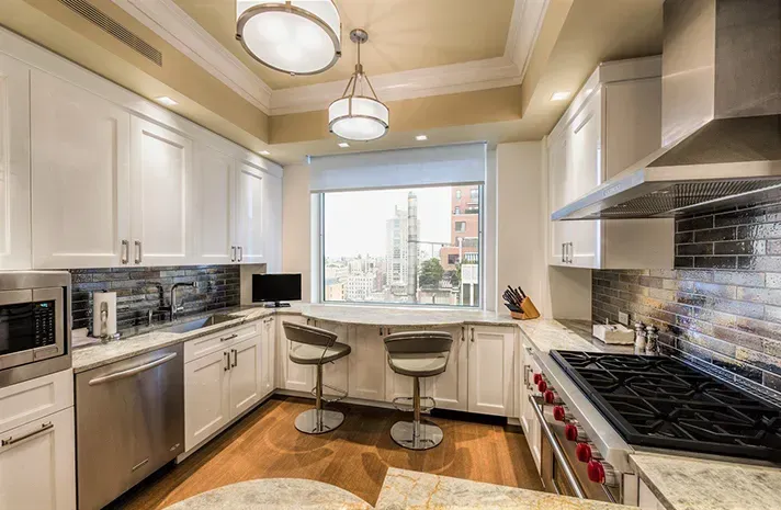 A kitchen with stainless steel appliances and white cabinets