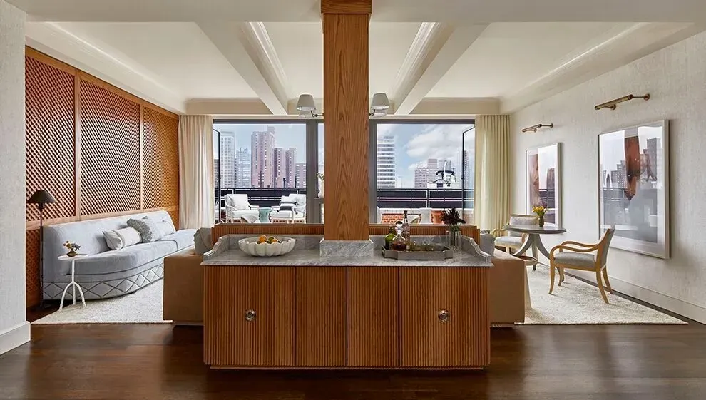 A living room with a couch , chairs , and a large island in the middle.