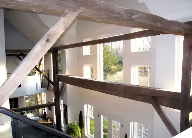 A room with a lot of windows and a wooden railing