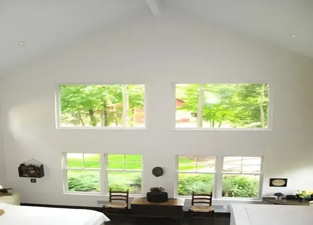 A bedroom with lots of windows and a bed