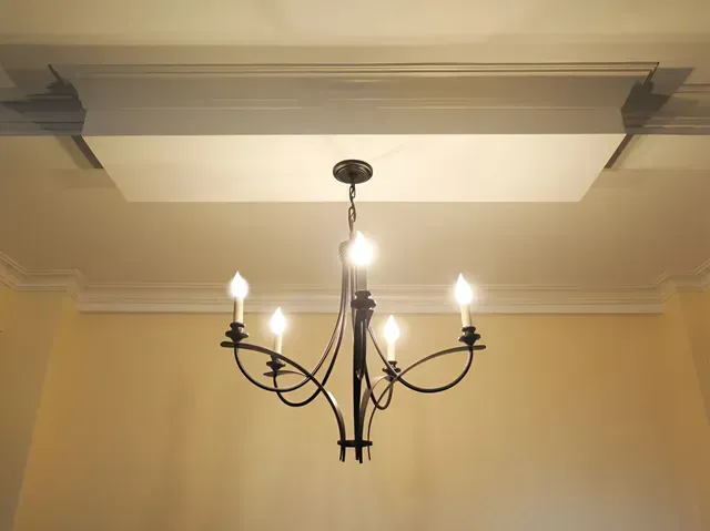 A chandelier is hanging from the ceiling in a room