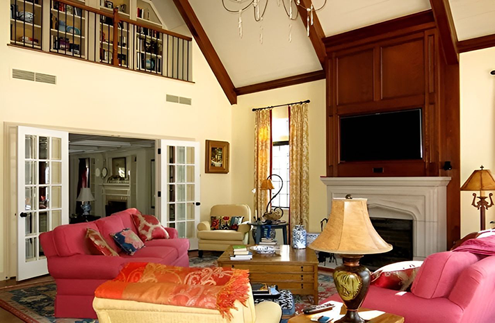A living room with pink furniture and a fireplace
