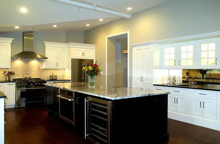 A kitchen with a large island and a vase of flowers on the counter.