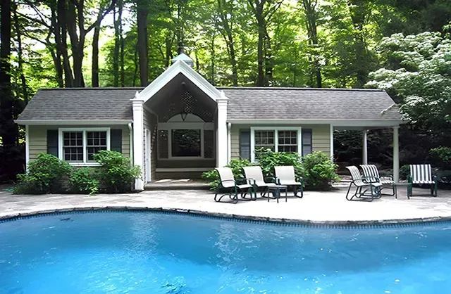 A house with a swimming pool in front of it