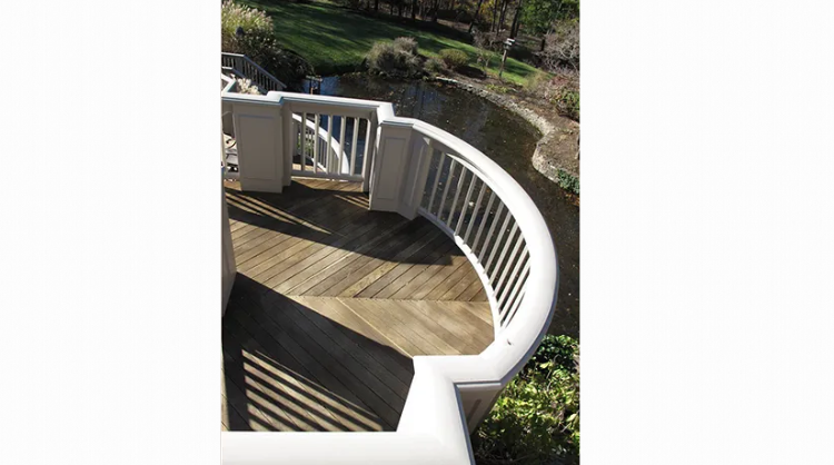 A wooden bridge over a river with a white railing