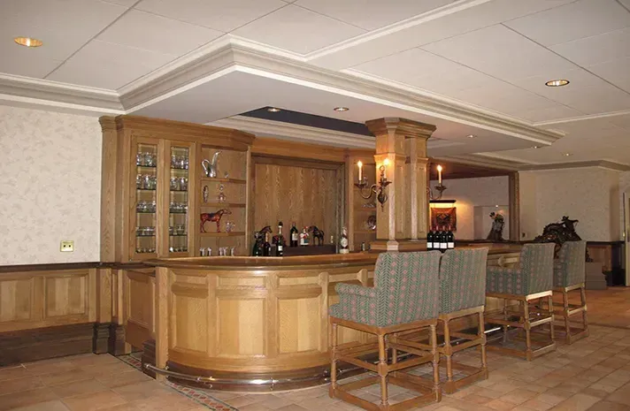 A large room with a bar and chairs in it