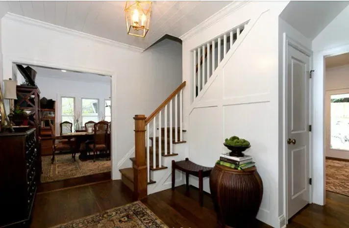 A hallway with stairs leading up to the second floor