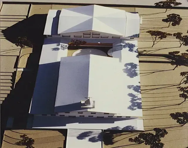 An aerial view of a model house with trees in the background