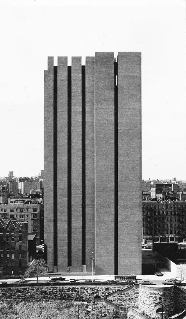 A black and white photo of a tall building in a city.