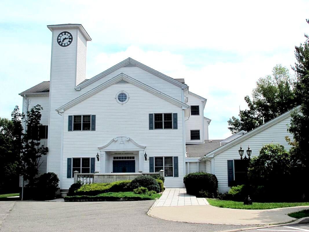 A large white house with a clock on top of it