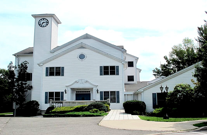 A large white house with a clock on top of it