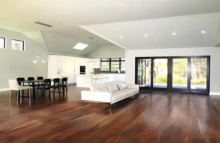A living room with hardwood floors , a couch , a table and chairs.
