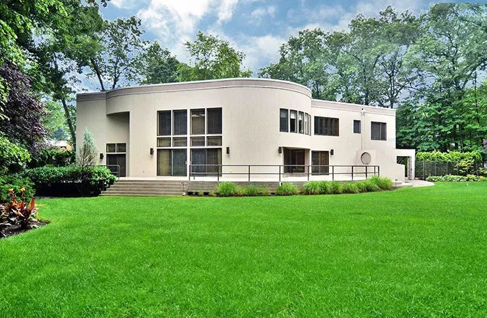 A large house with a lush green lawn in front of it