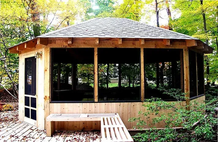 A screened in gazebo in the middle of a forest
