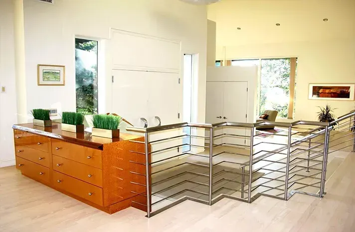 A living room with a staircase and a dresser