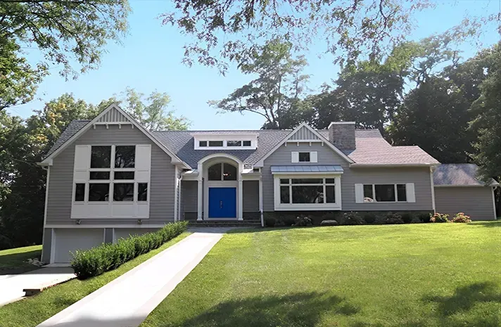 A large house with a blue door and white shutters