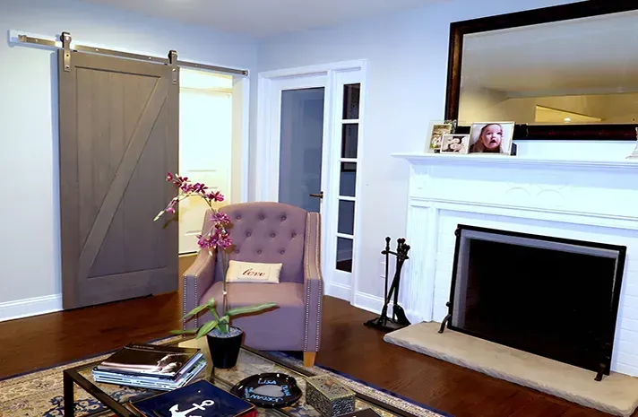 A living room with a fireplace and a sliding barn door