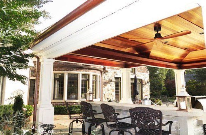 A patio with a table and chairs under a ceiling fan
