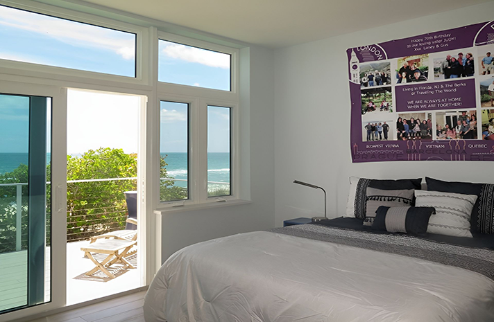 A bedroom with a large bed and a purple poster on the wall
