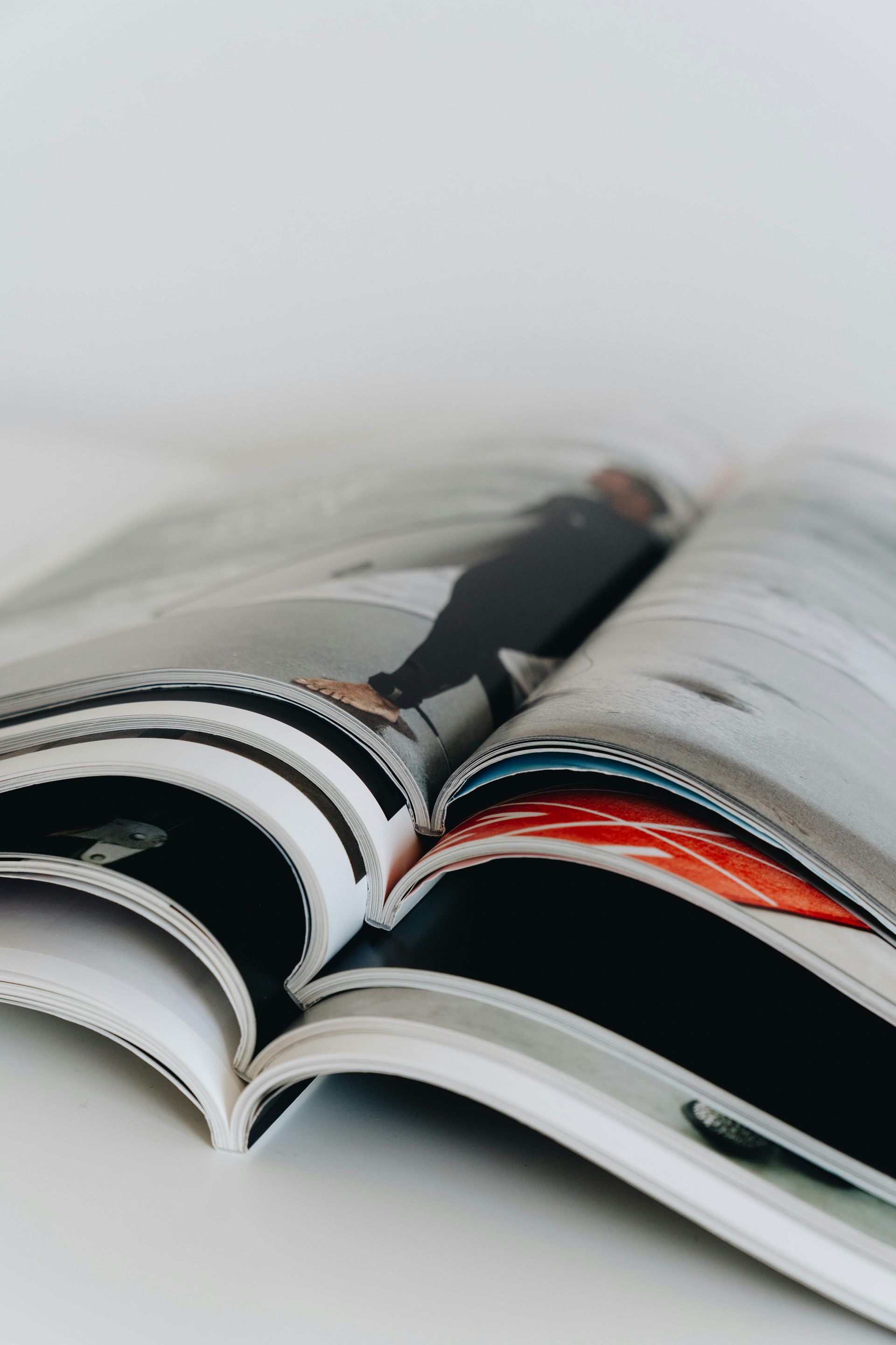 Open magazine with glossy pages fanned out on a white background