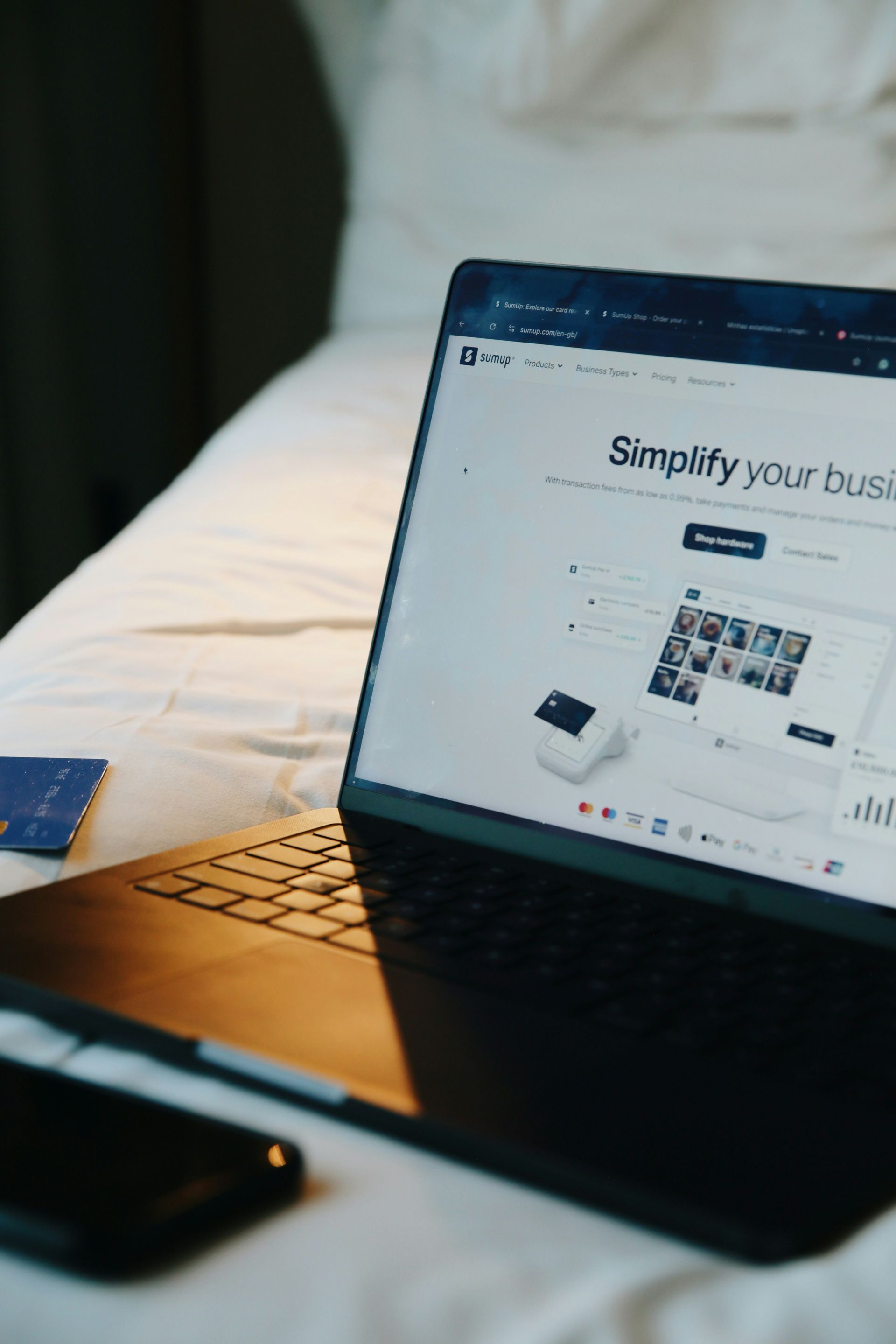 Laptop displaying a business website on a desk beside a phone