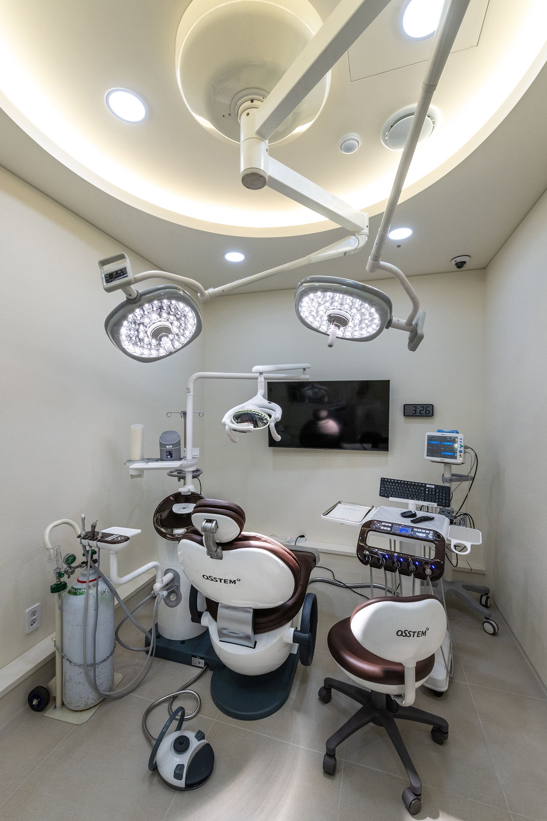 Dental office with medical chair, equipment, and operating lights.