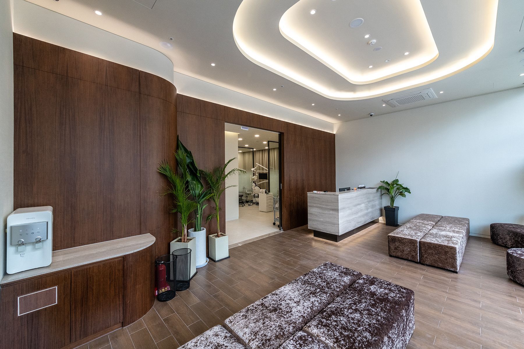 Reception area with brown wood paneling, a modern reception desk, and seating.