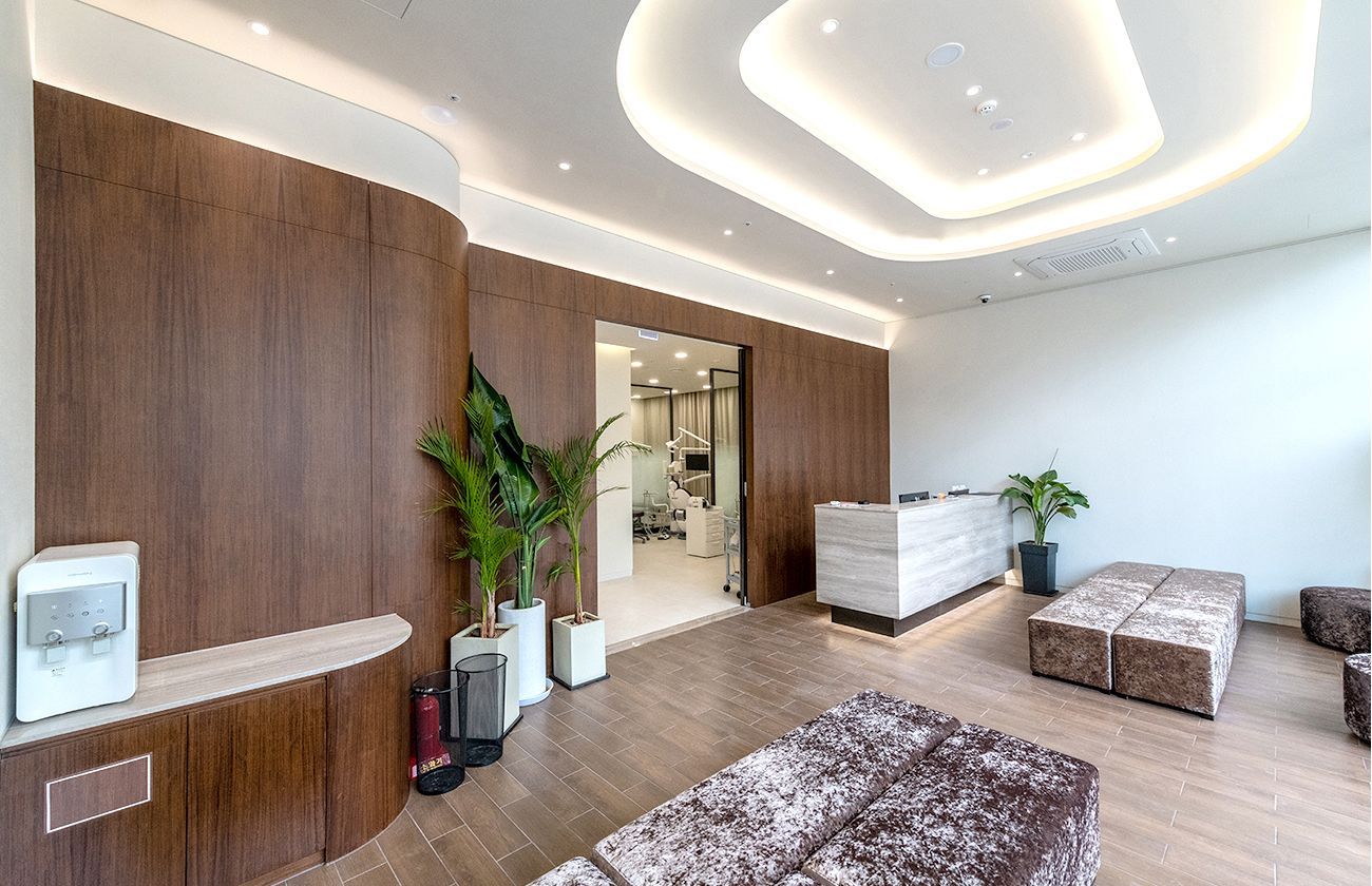 Modern waiting room with wooden paneling, a reception desk, and seating.