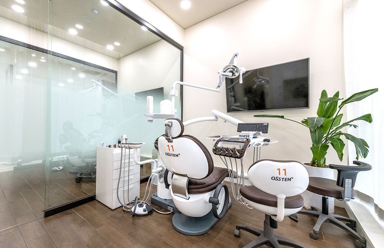 Dental office examination room with a chair, tools, and a television.