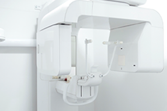 Dental panoramic X-ray machine, white, in a dental office setting.