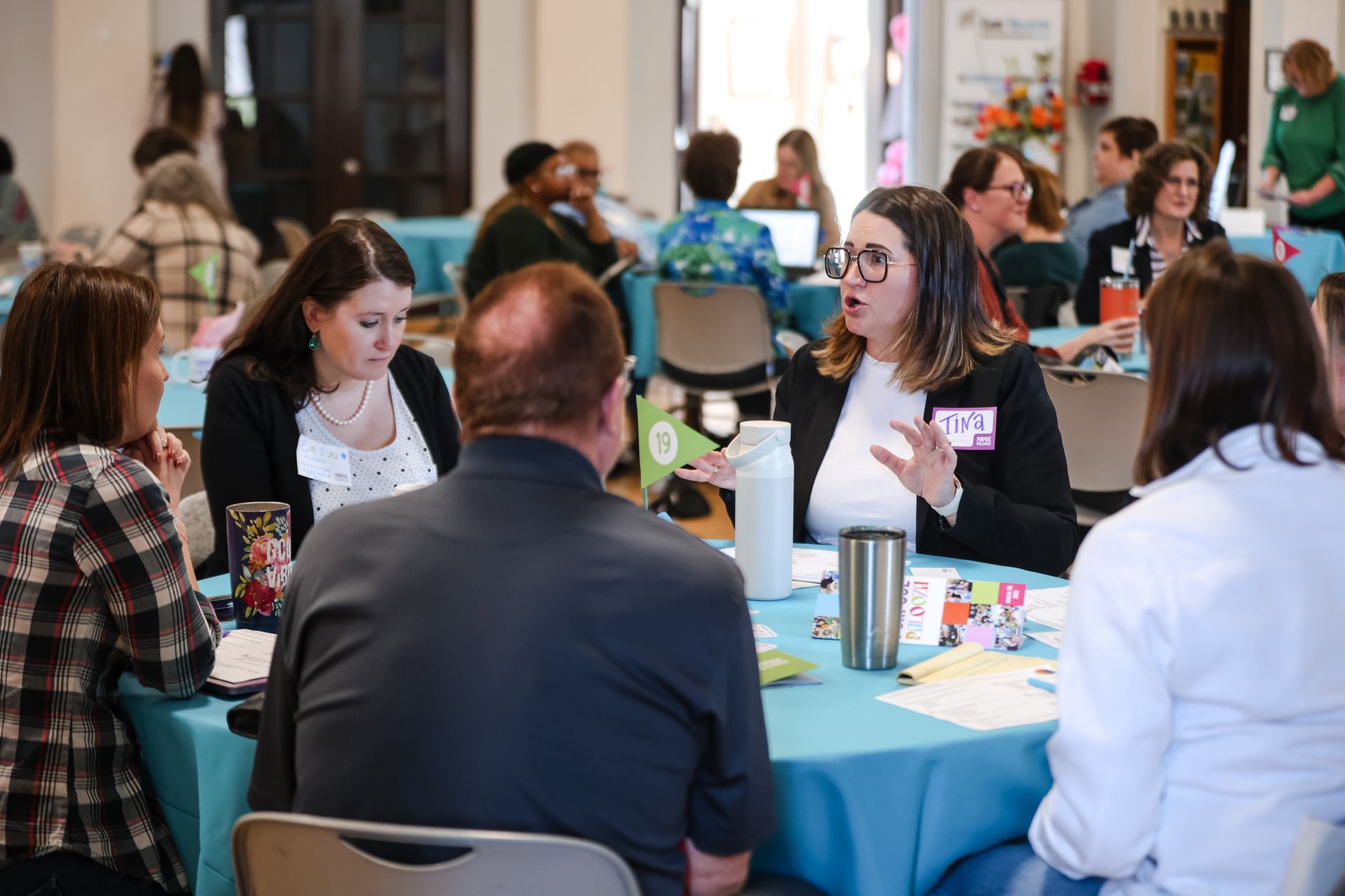 photo of woman speaking and others at the roundtable listening