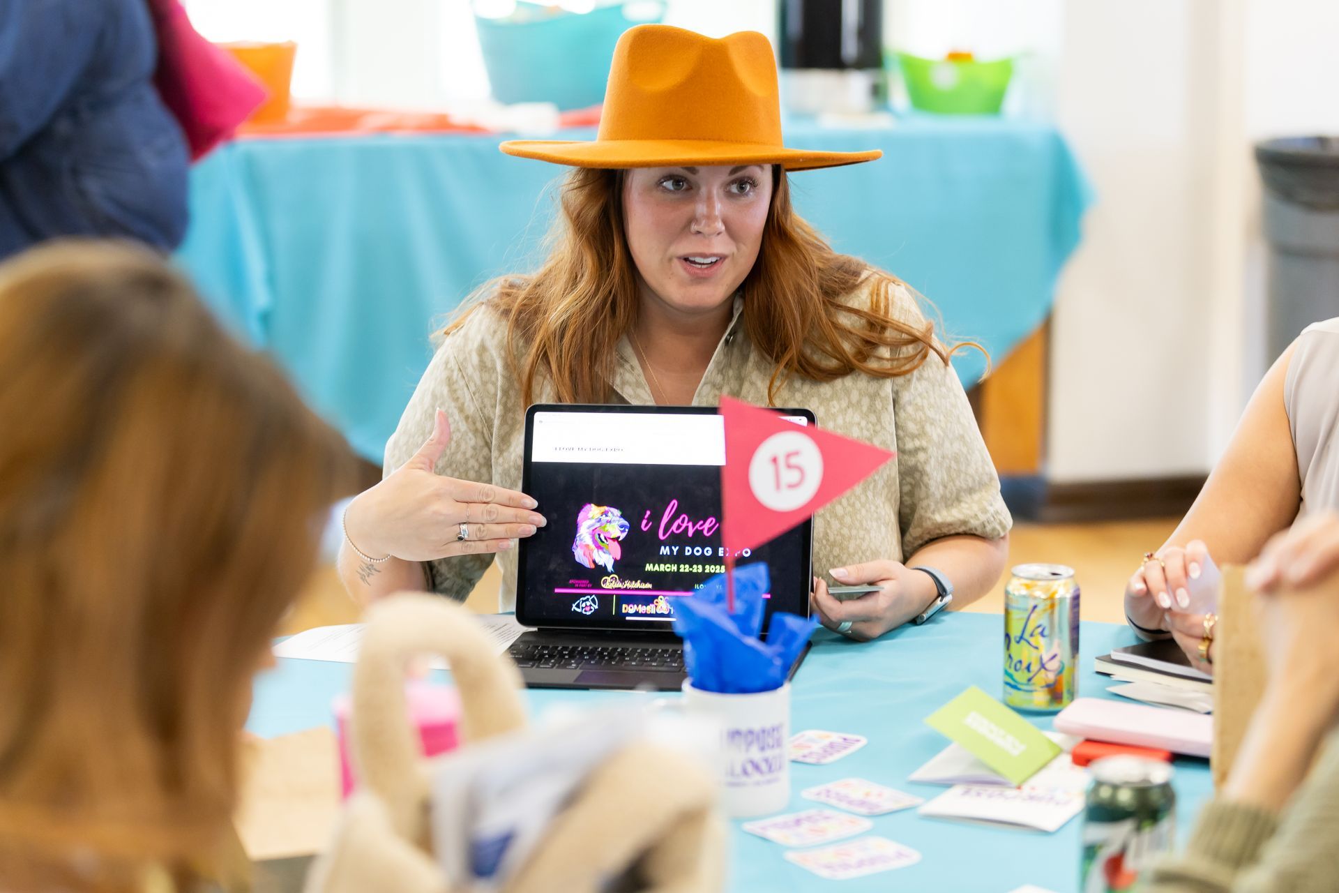 photo of woman speaking while gesturing to a laptop