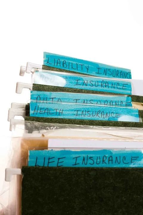 Turquoise tabs labeled “disability insurance” and “life insurance” on a white binder or folder