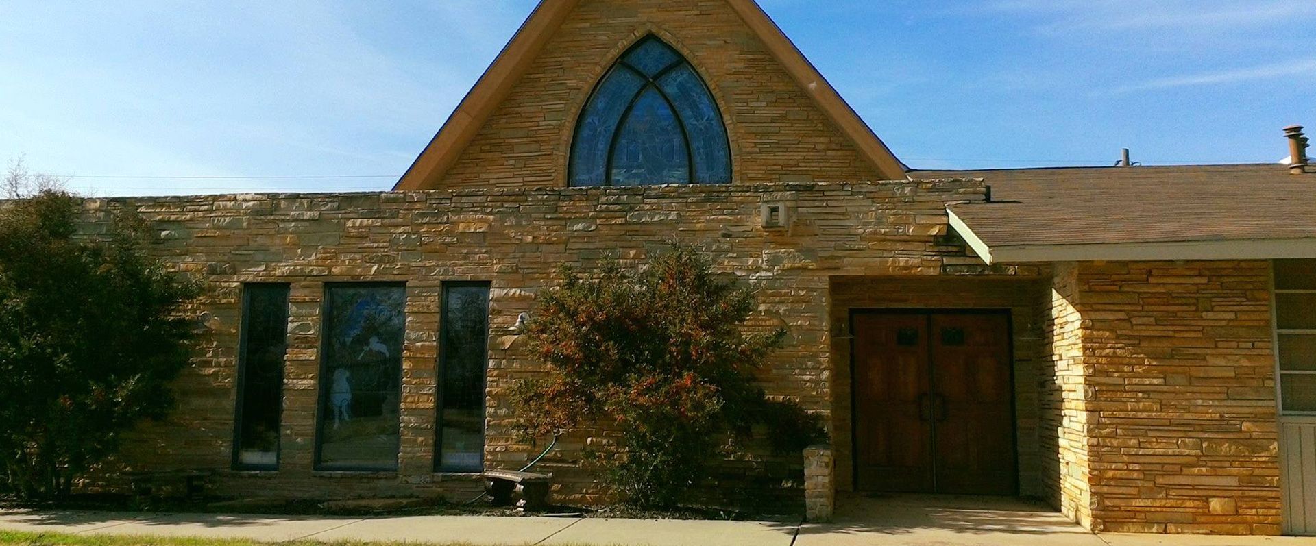 A brick building with a large window and a wooden door