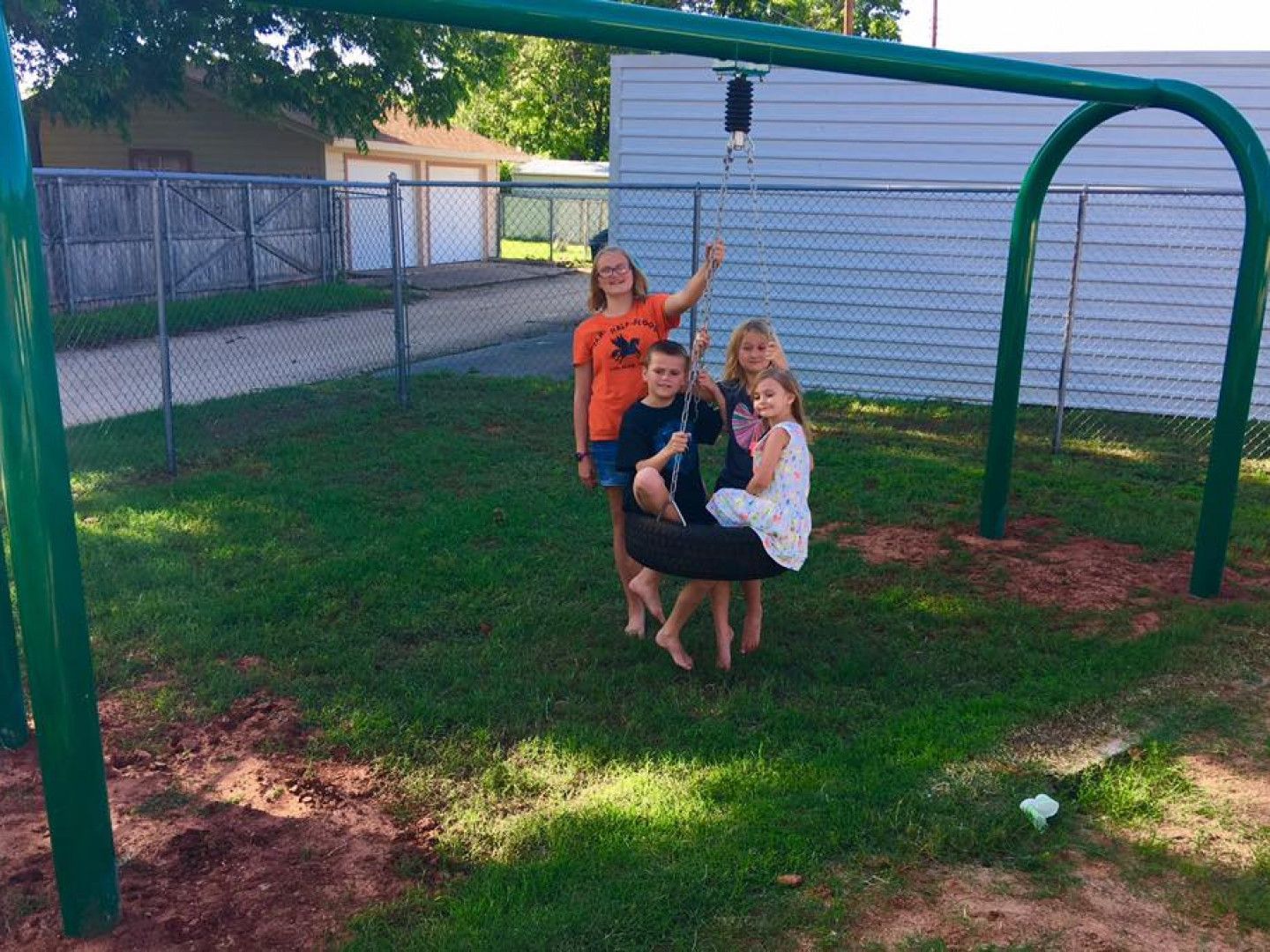 A group of children are playing on a swing set.