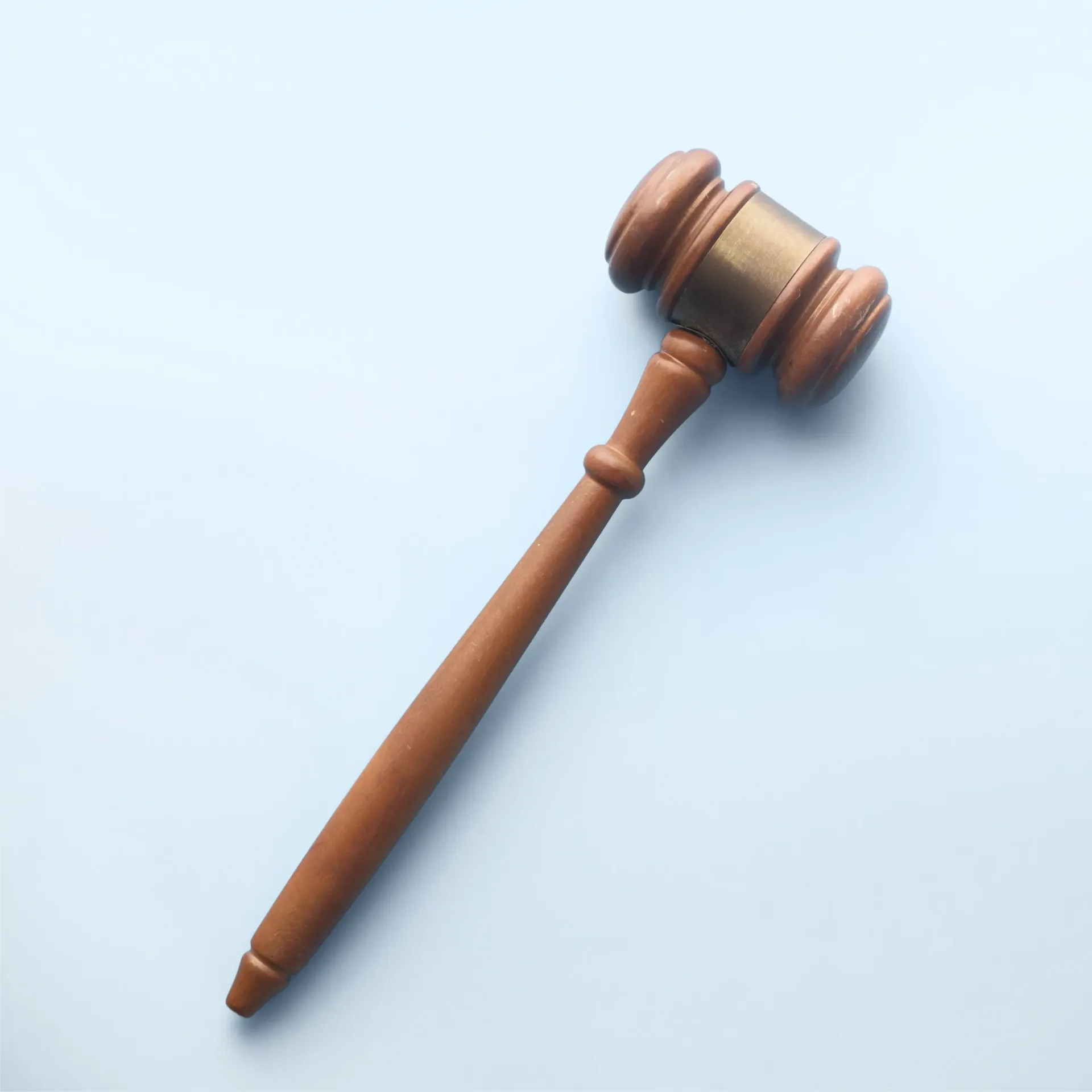 A wooden judge 's gavel is sitting on a blue surface