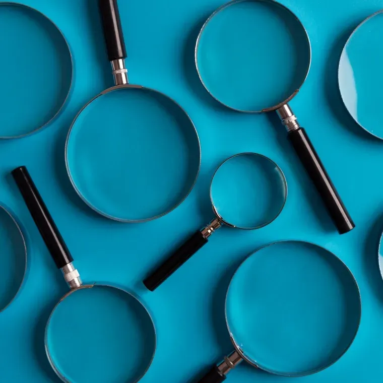 A bunch of magnifying glasses on a blue surface