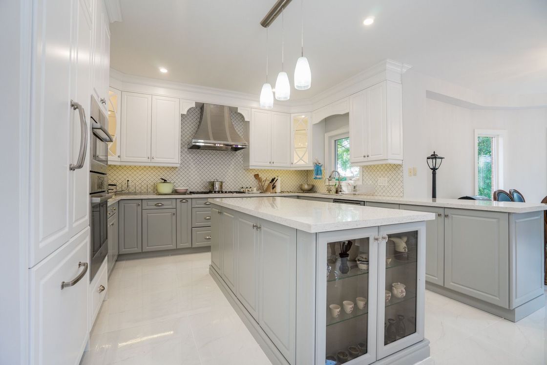 A kitchen with white cabinets and a large island in the middle.