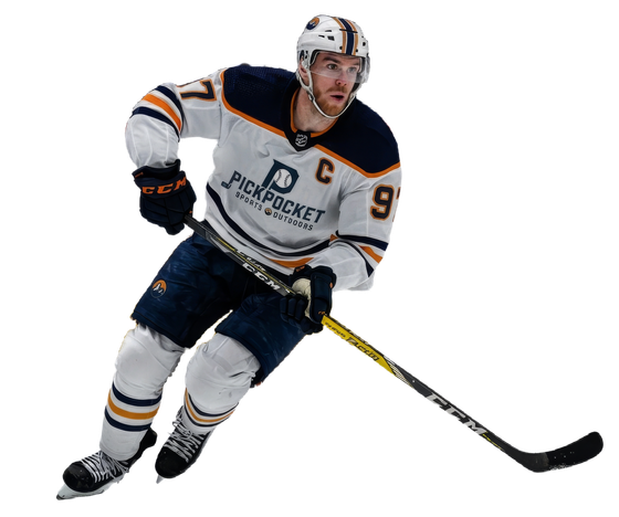 Ice hockey player in white and navy uniform skating with the puck on a white background