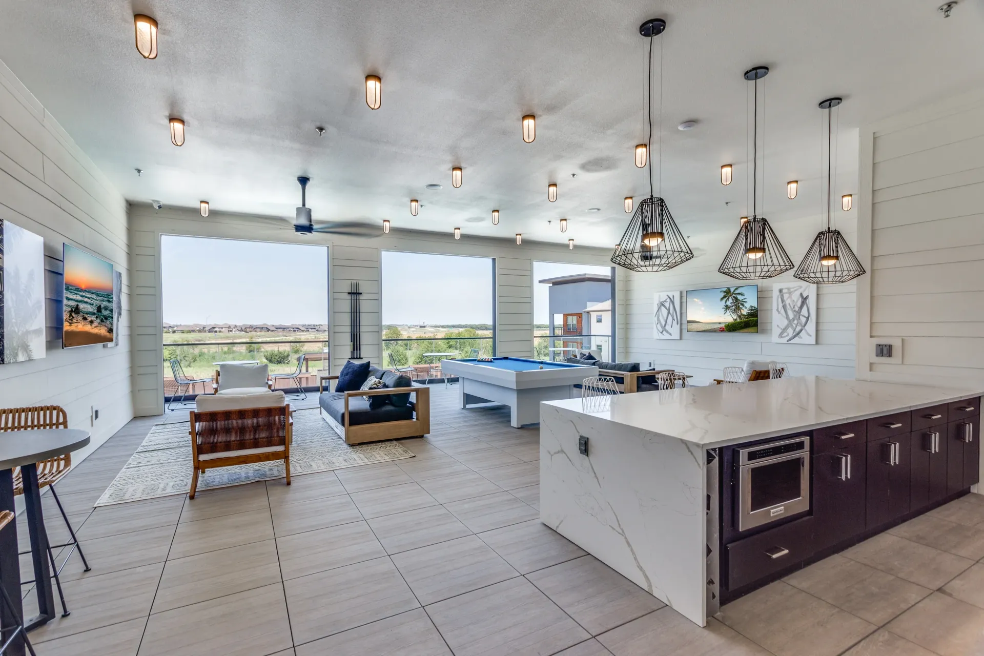 Interior communal lounge area with a pool table, seating, and a kitchen island.